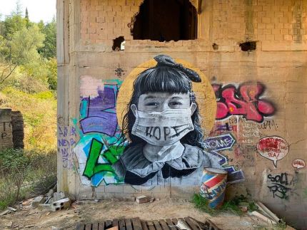 Photo d'une oeuvre de street art représentant un enfant avec un masque chirurgical